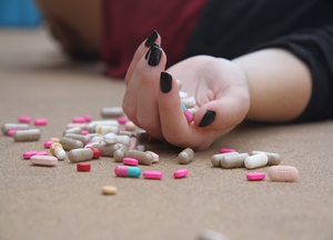 Comportamento suicida - mãos cheias de pílulas de uma mulher que cometeu suicídio.