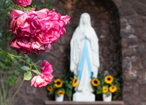 Imagem de Nossa Senhora em uma gruta ao fundo.